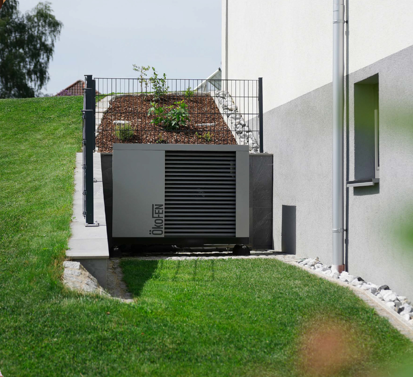 Luft-Wasser-Wärmepumpe von ÖkoFEN in Aussenaufstellung neben einem Einfamilienhaus.